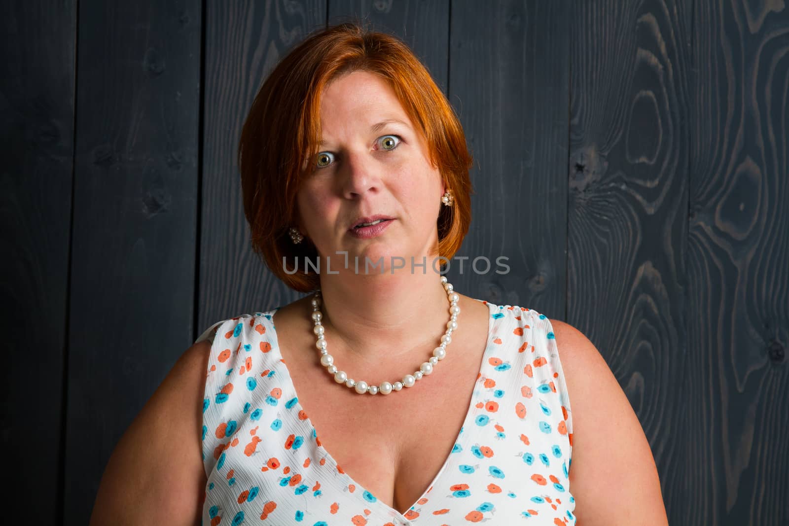 forty something brunette woman wearing a sun dress with an annoyed expression