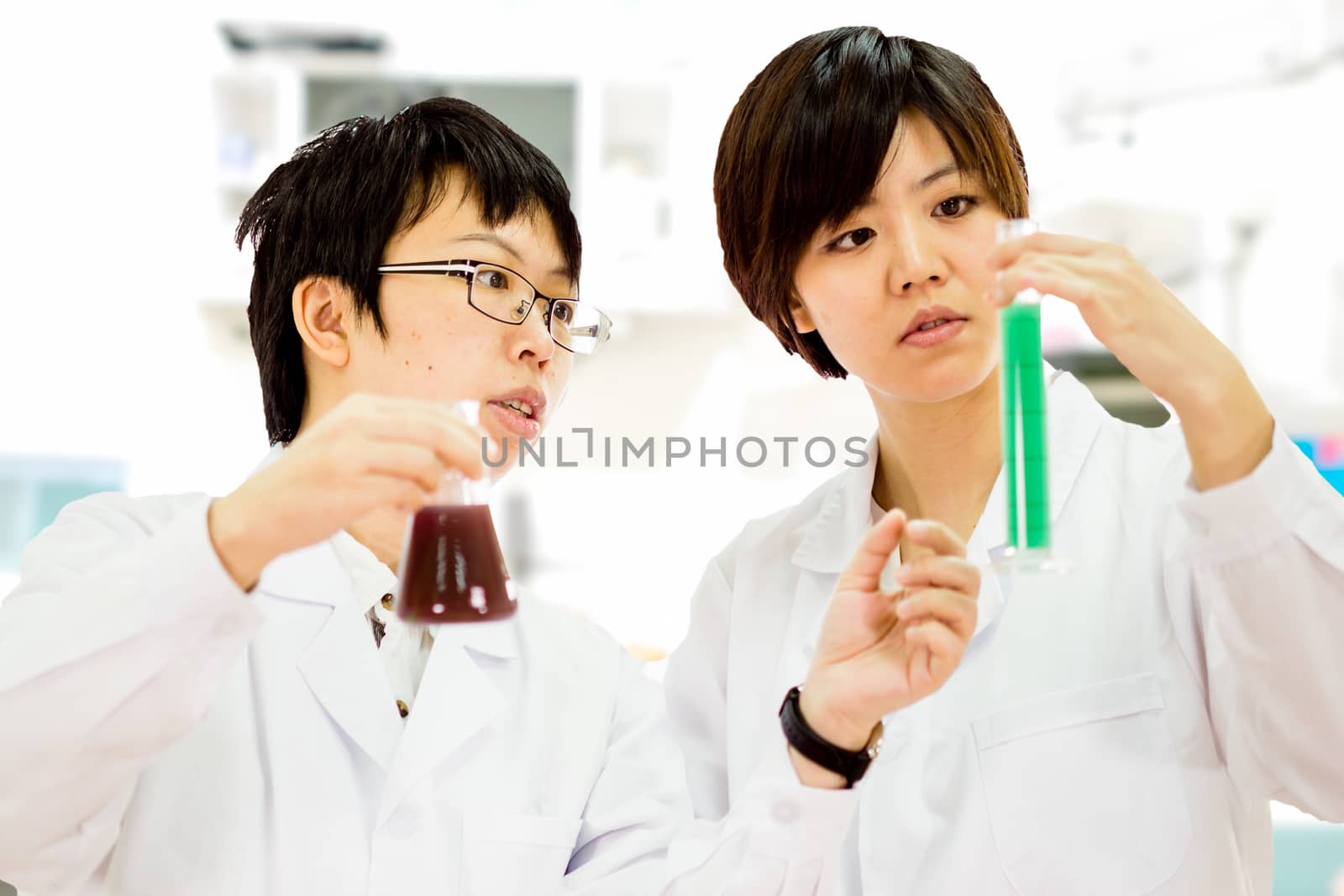 Female Chinese scientists in a laboratory inspecting chemicals in tube