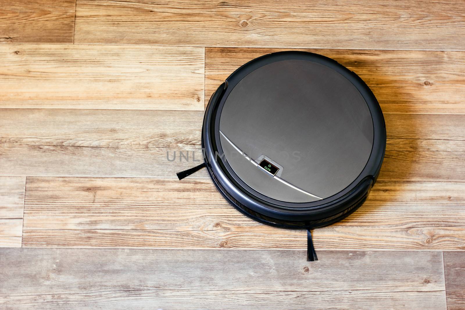 robot vacuum cleaner on the parquet floor in the apartment