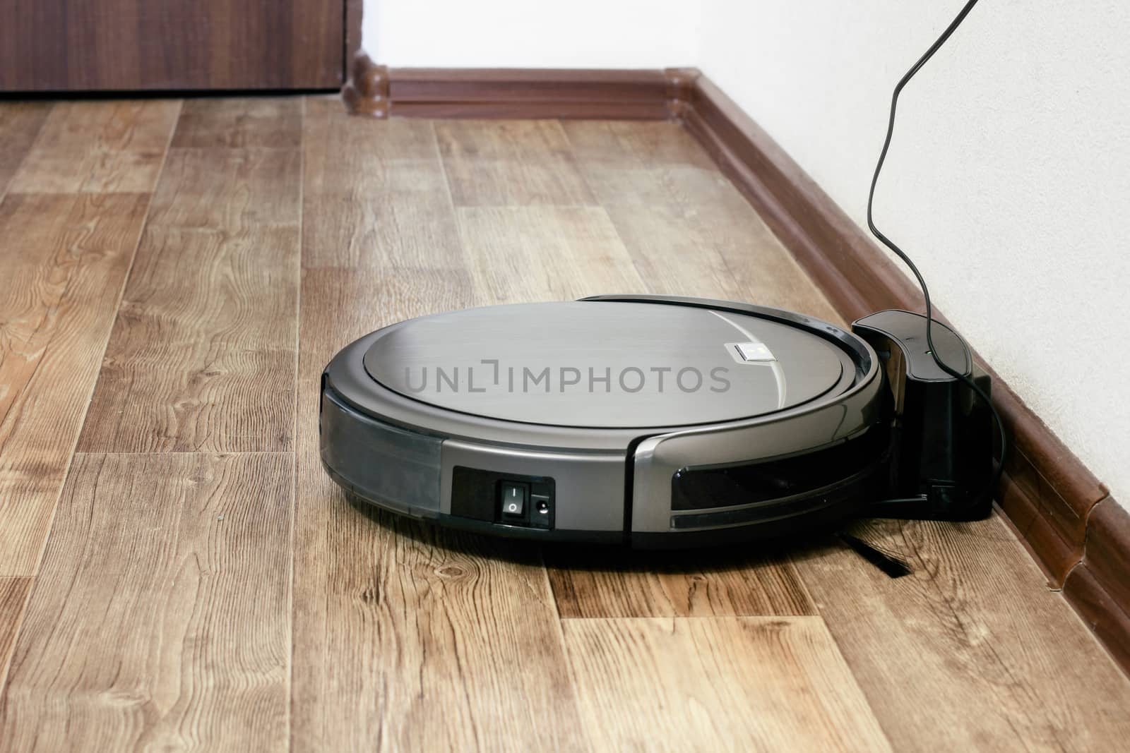 robot vacuum cleaner on the parquet floor in the apartment