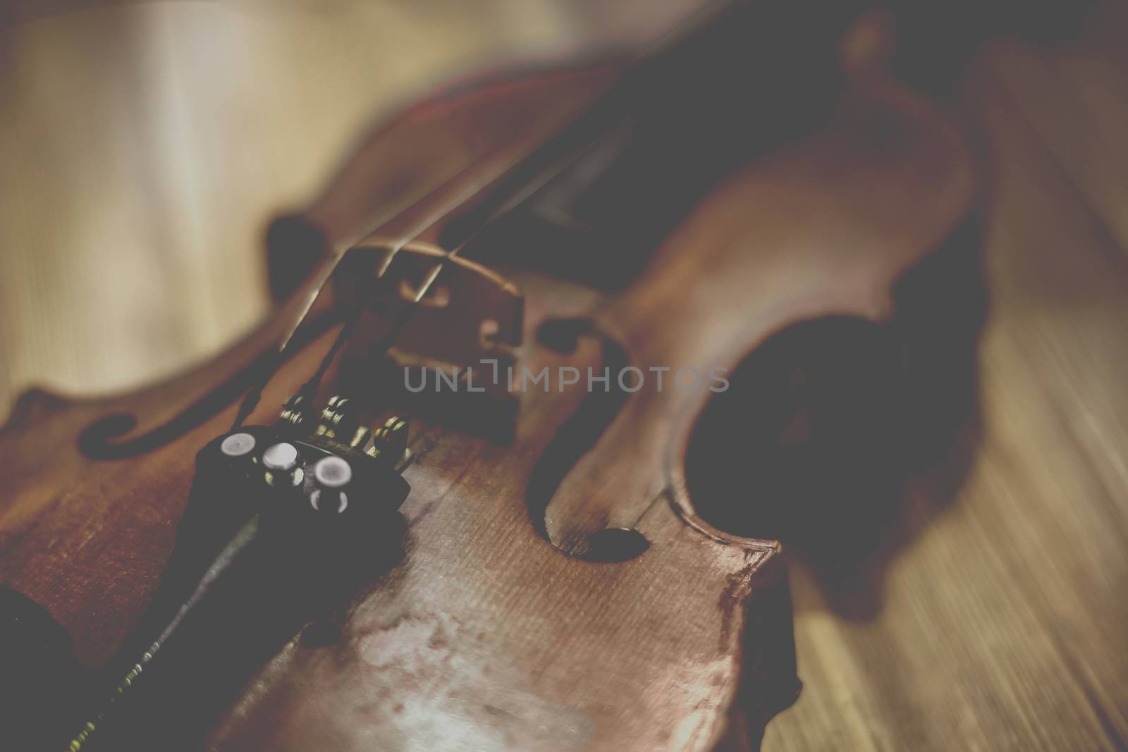 Old violin lying on a wooden surface by sermax55