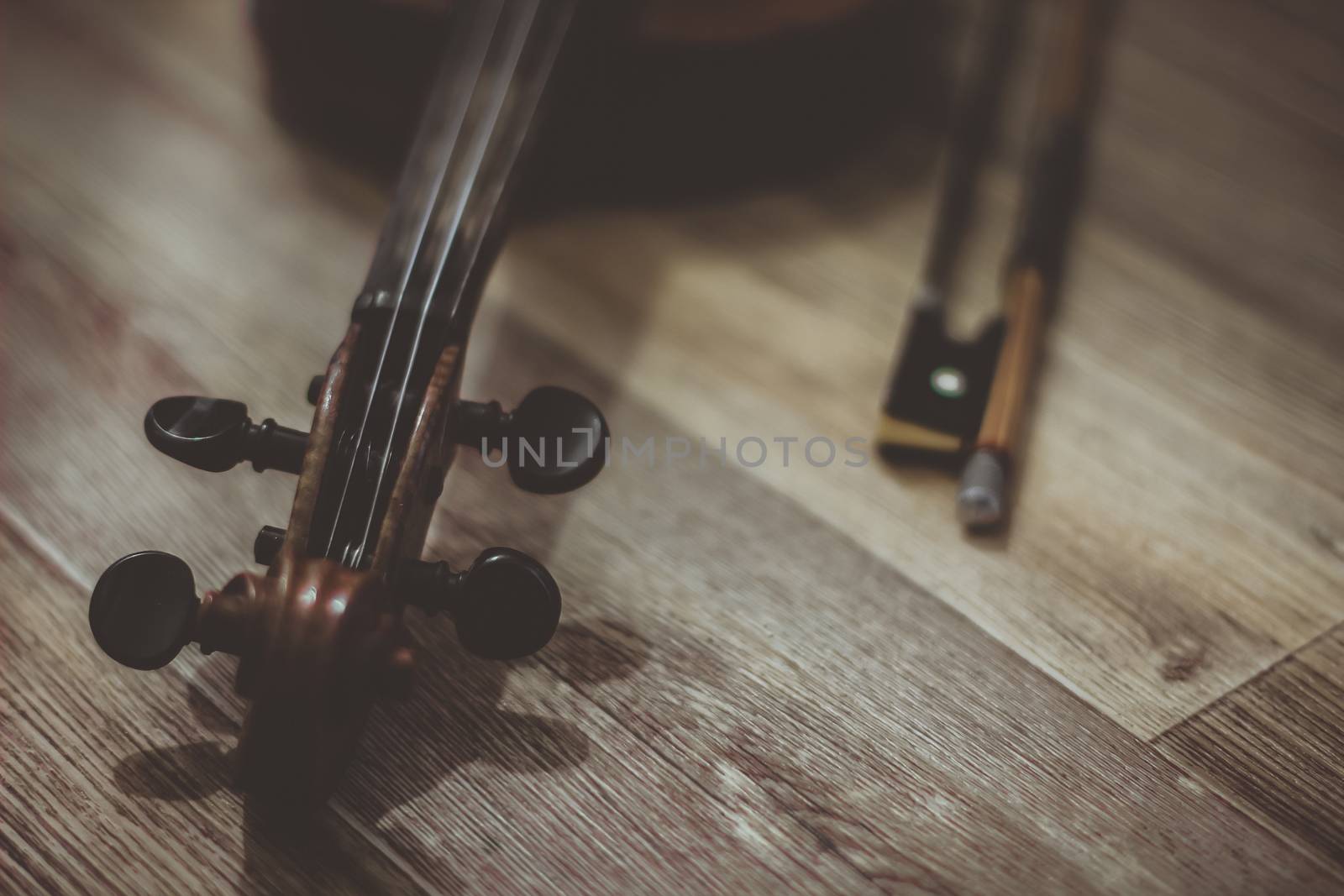 Old violin lying on a wooden surface by sermax55