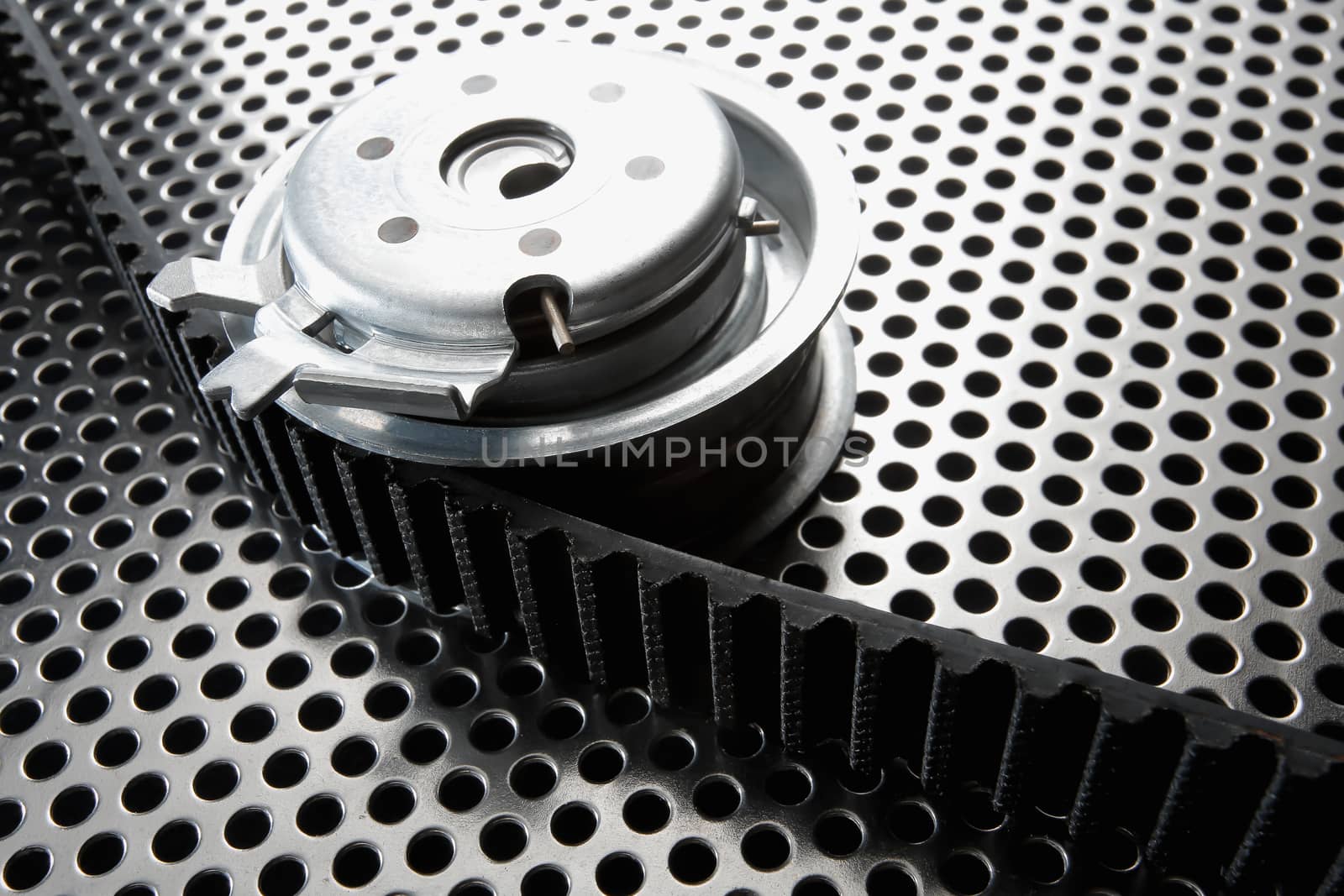 Bearing tensioner and timing belt on a metal surface. Photo from the vignetting effect