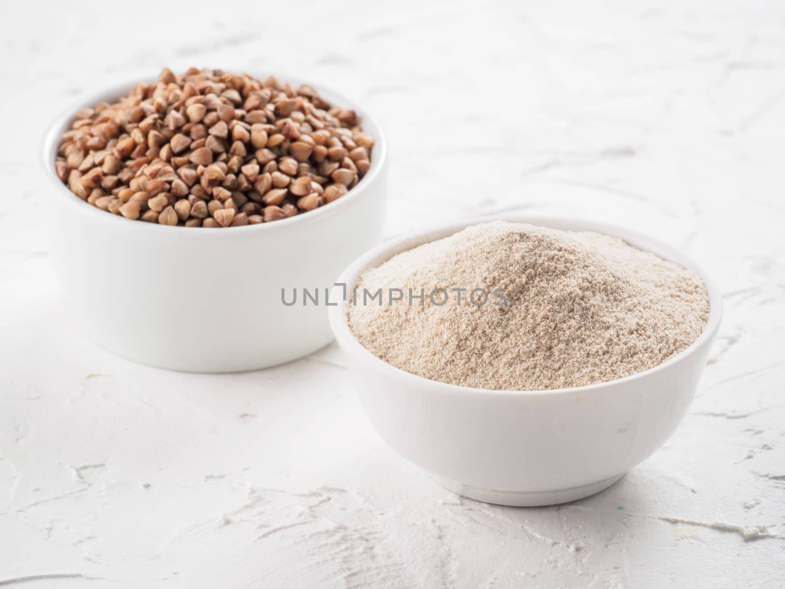 Buckwheat flour and buckwheat on white background Copy space.