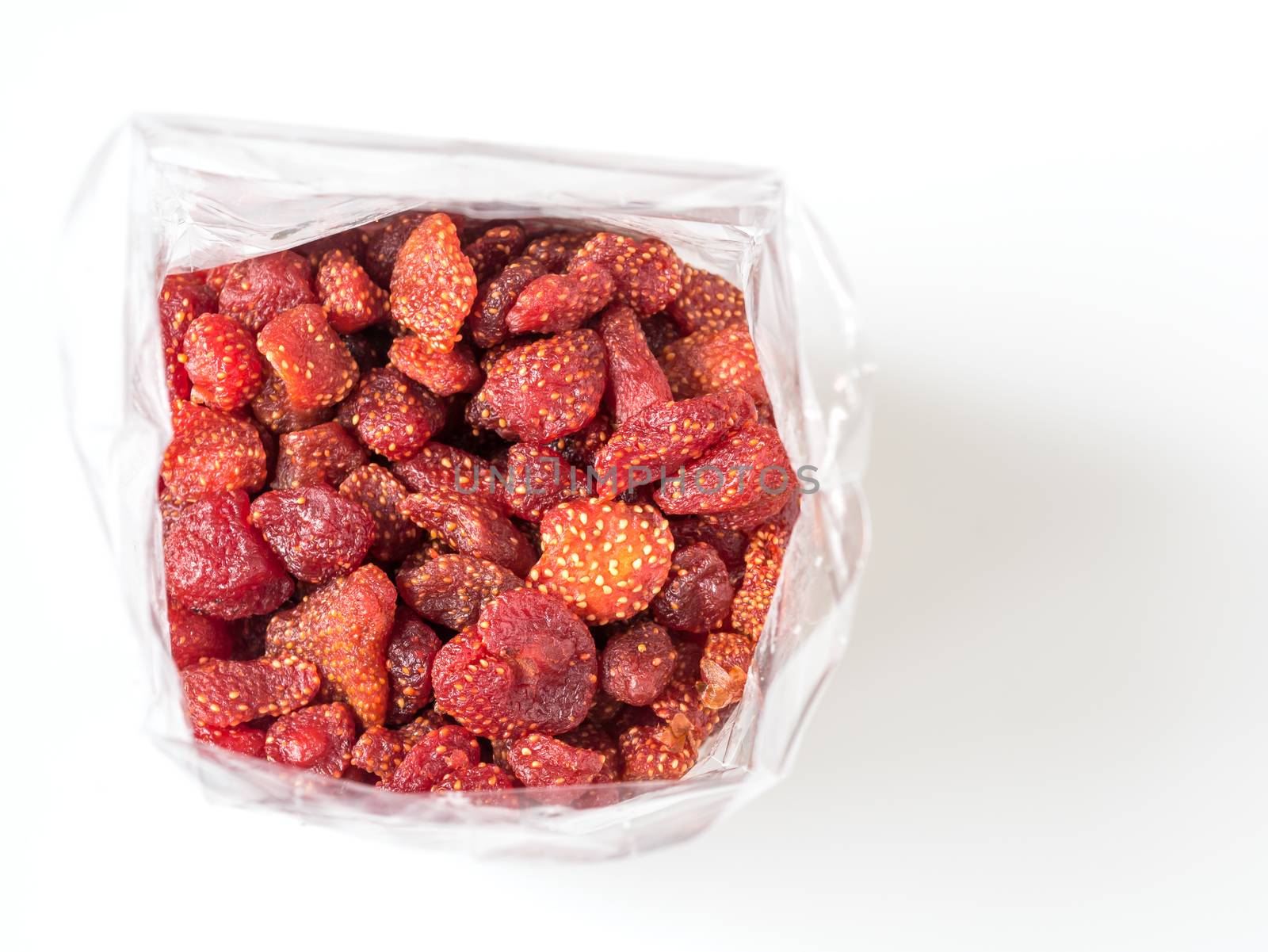 Closeup dried strawberry bake with honey in plastic bag on white background