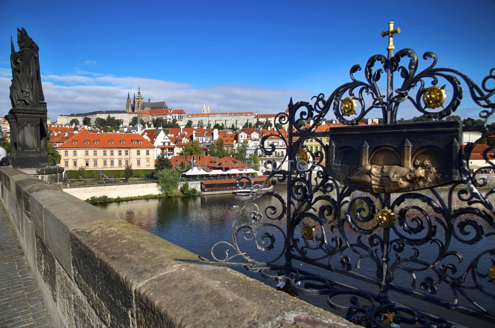 Panoramic view on St. Vitus Cathedral from Charles Bridge with Statues of Saints Norbert, Wenceslaus and Sigismund and bronze relief for good luck in Prague, Czech Republic
