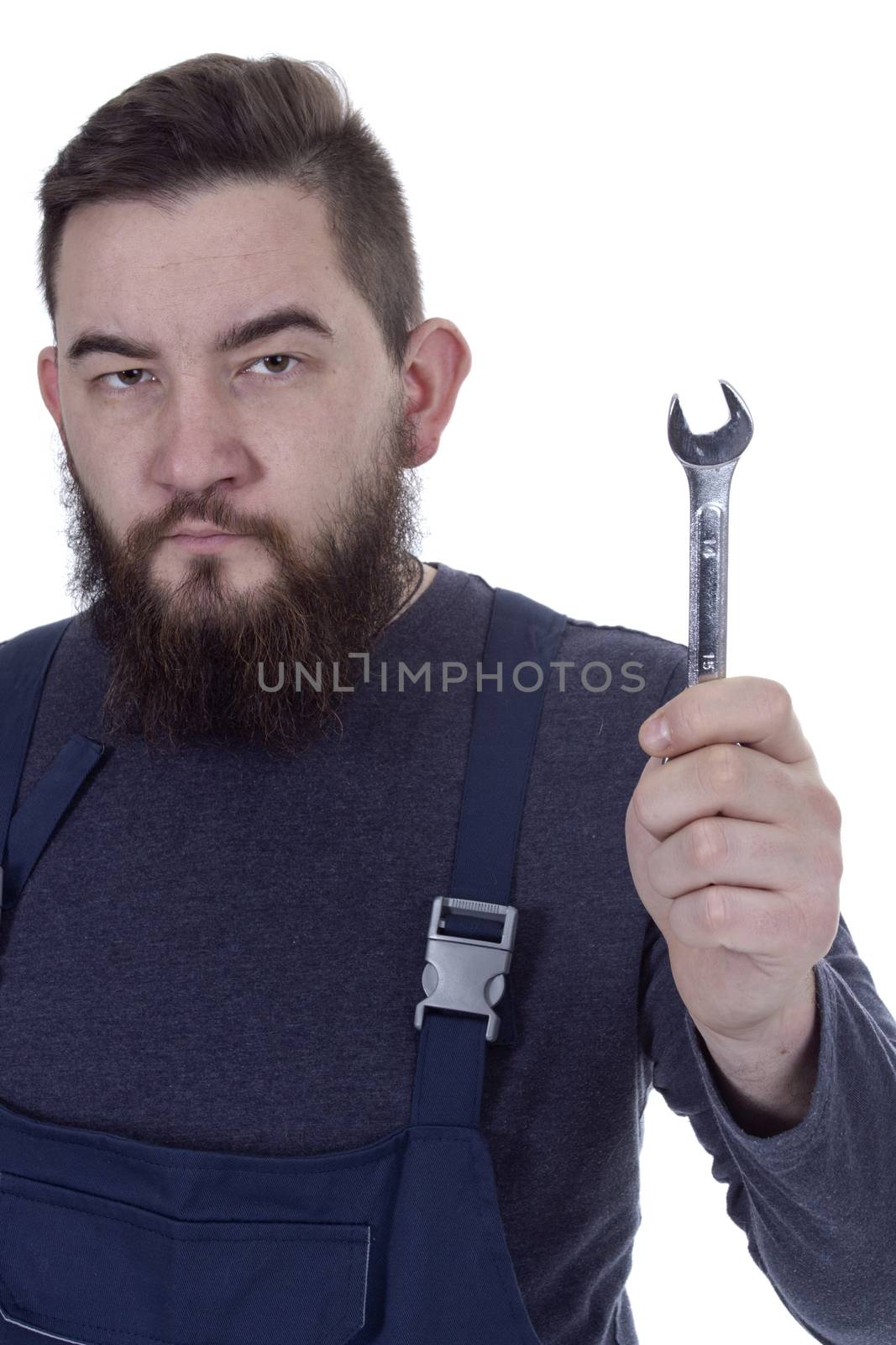 Bearded young man with a wrench in a working overall