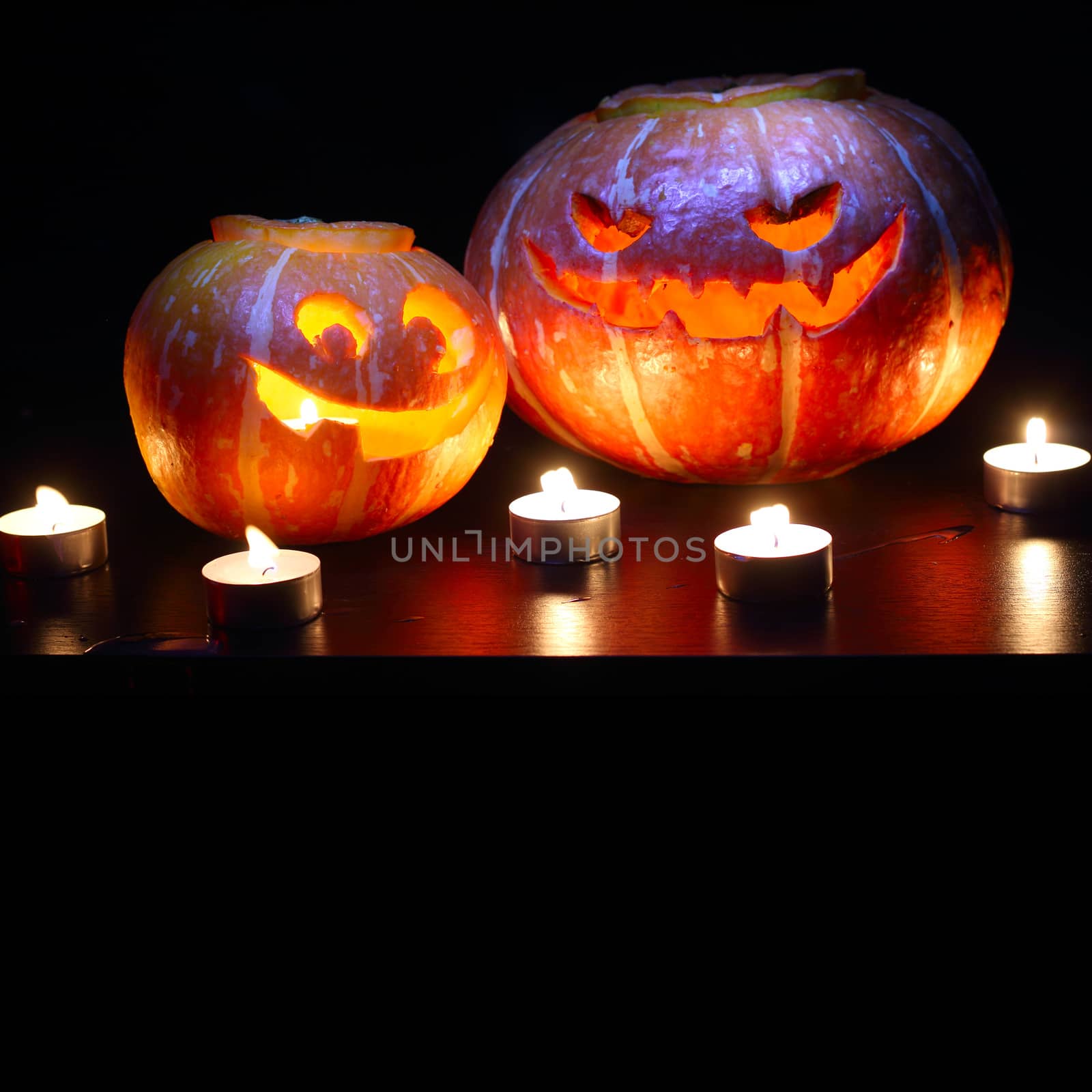 Illuminated cute halloween pumpkins isolated on black background