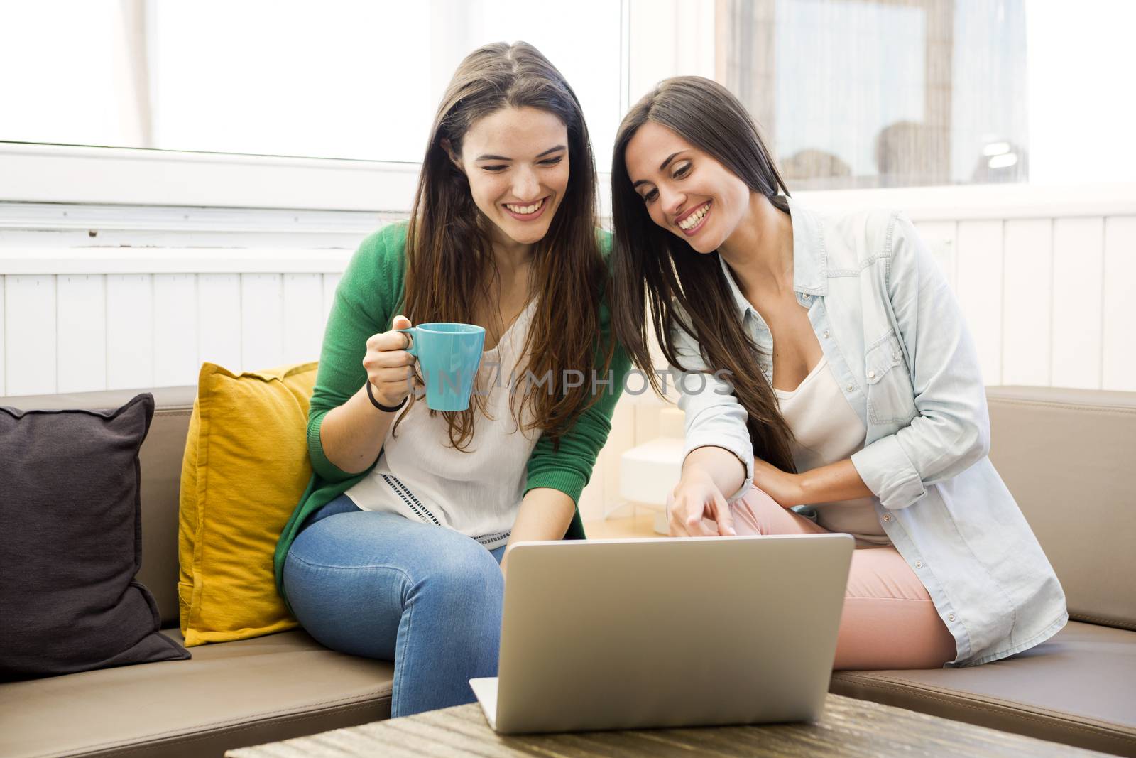 Female friends at the local coffee shop drinking coffee and working