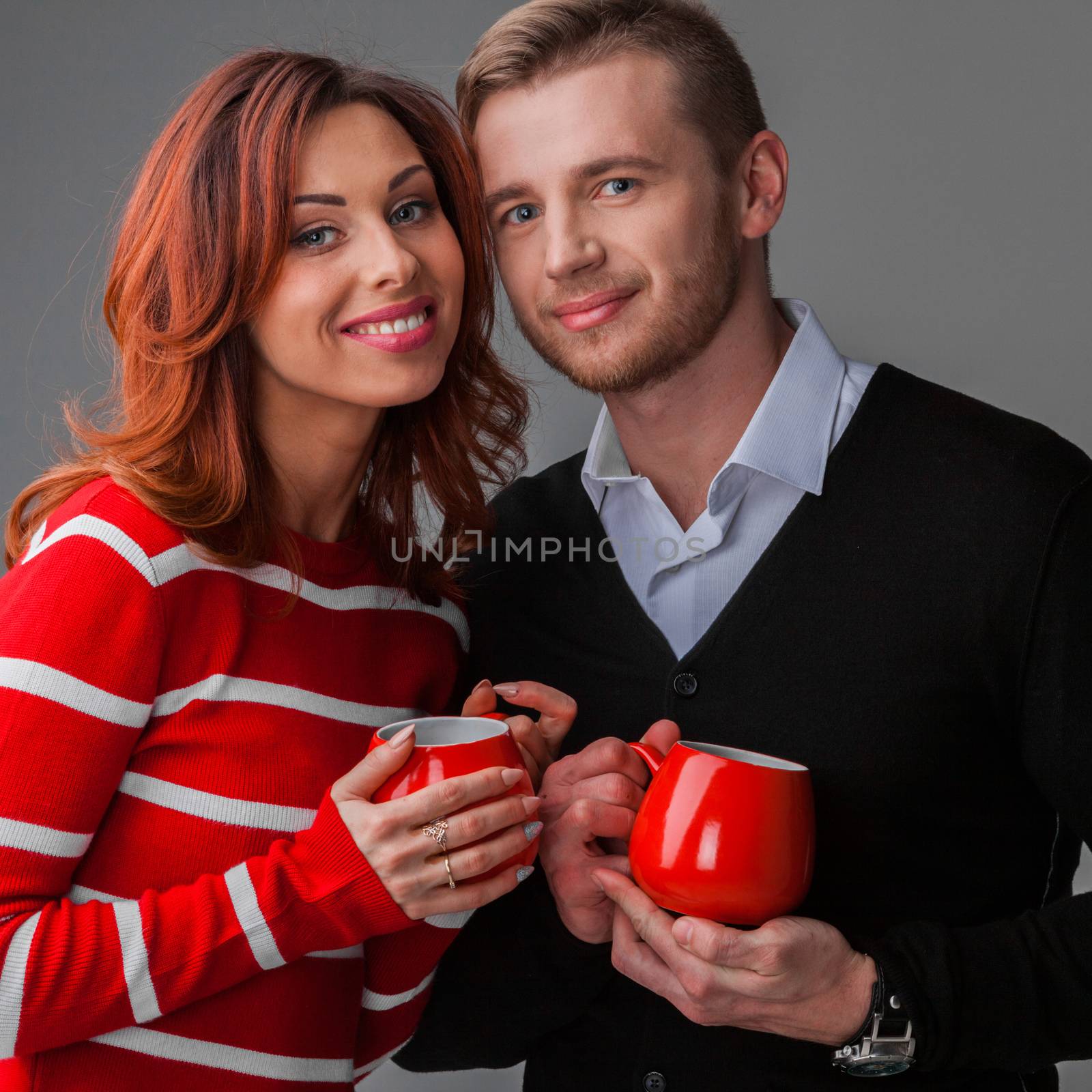 Happy couple in love holding red cups, Valentines day concept
