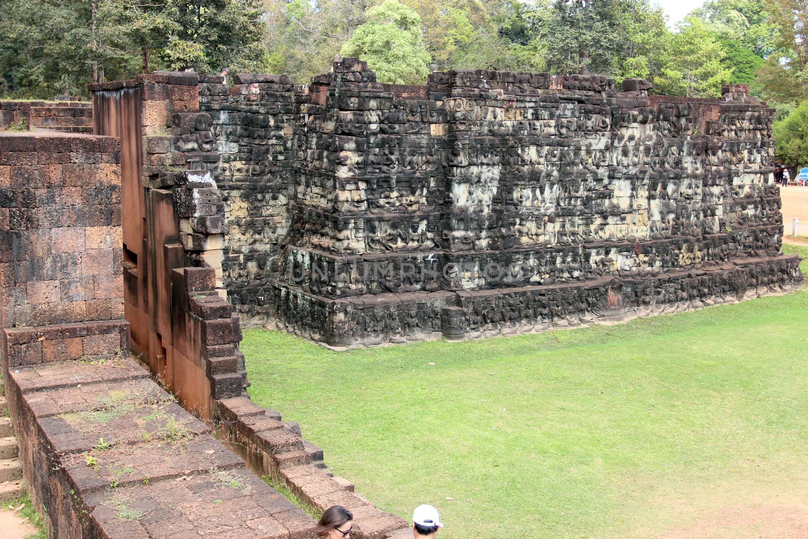 Brick and stone masonry of the ancient walls of the Cambodian temple, with reliefs and sculptures, pillars and columns on a natural background