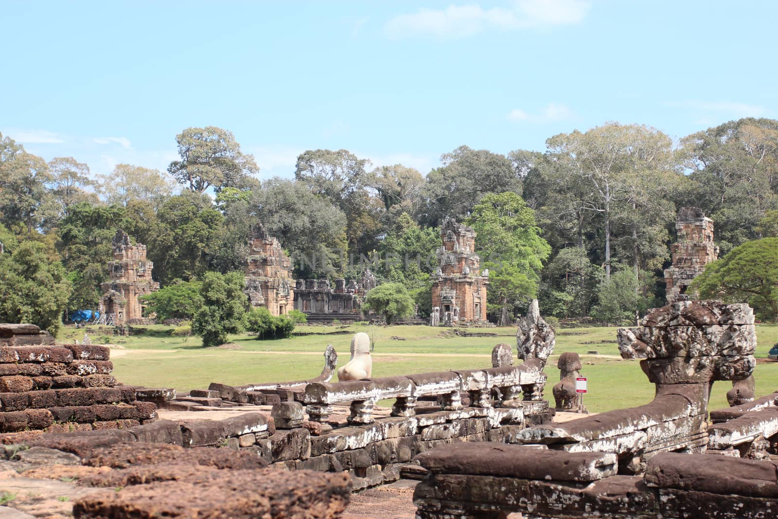 Brick and stone masonry of the ancient walls of the Cambodian temple, with reliefs and sculptures, pillars and columns on a natural background
