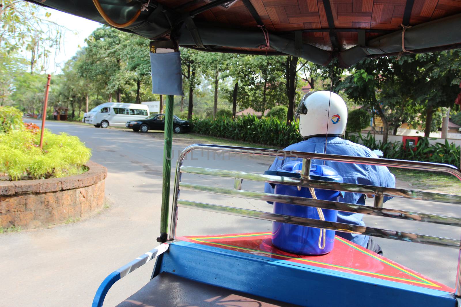 view from the tuk-tuk to the driver in the helmet and the road. Cambodia.