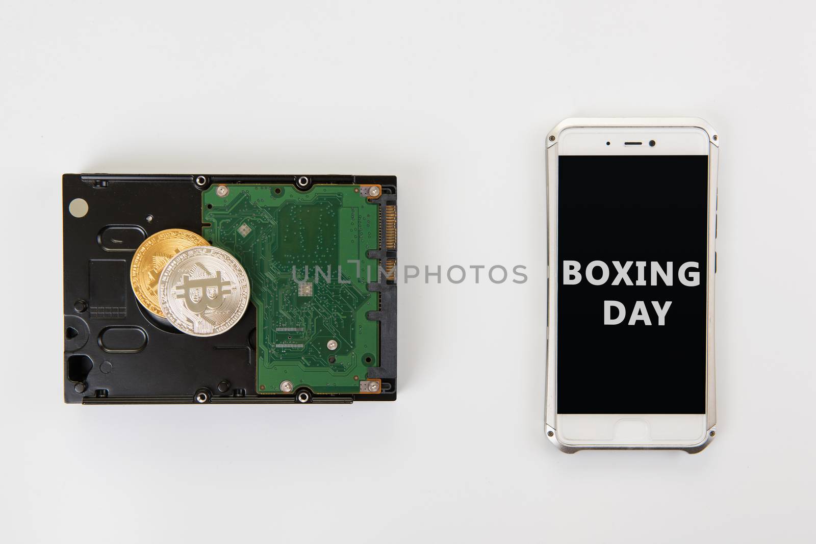 Bitcoin coins on the HDD and phone with Boxing day sign