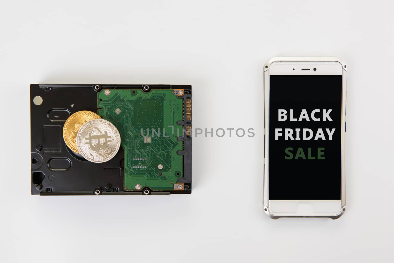 Bitcoin coins on the HDD and phone with Black Friday sign