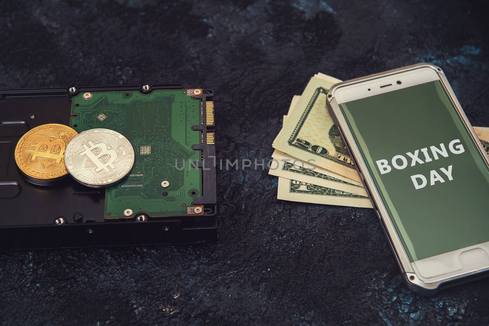 Bitcoin coins on the HDD and phone with Boxing day sign