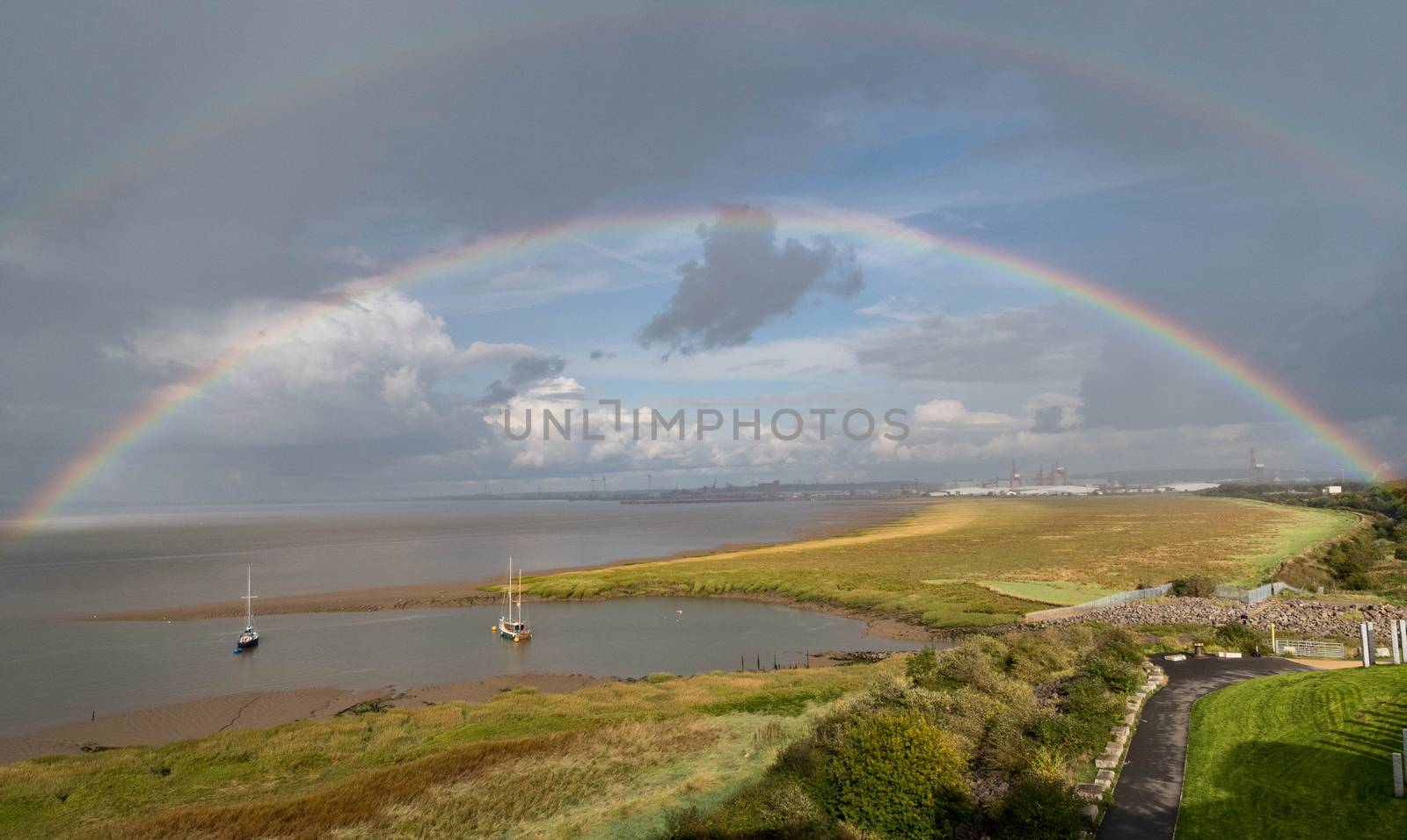 a rainbow arches over yachts moored on the Bristol channel
