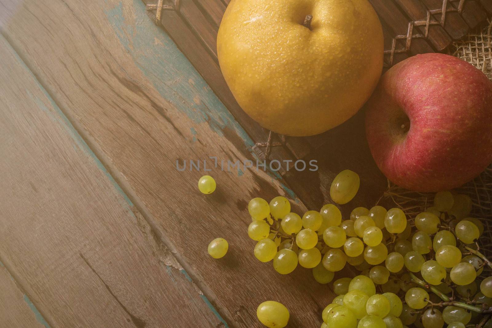 Apple and pear on old wooden floor.