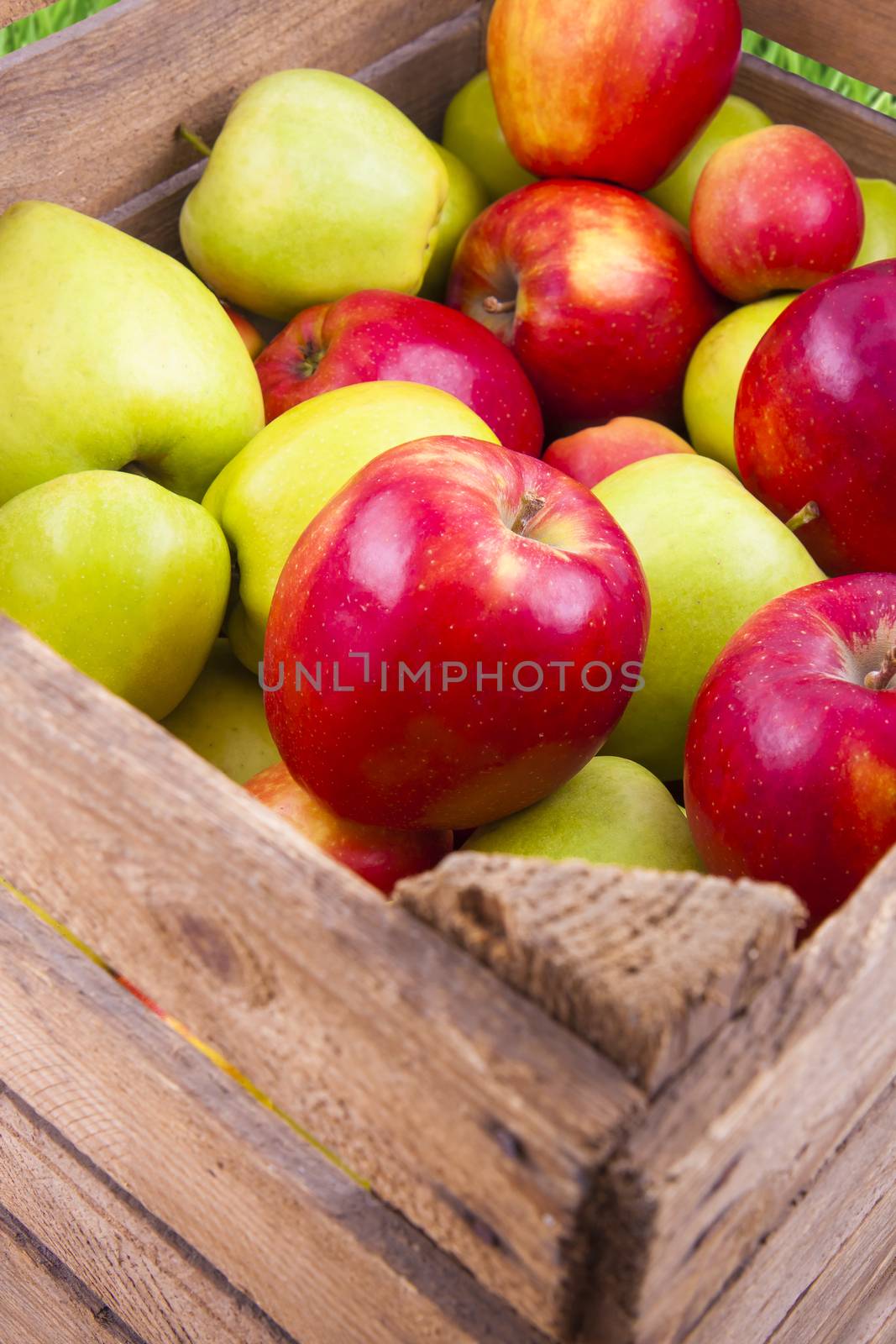 Fresh green and red apples in a wooden box, fruits