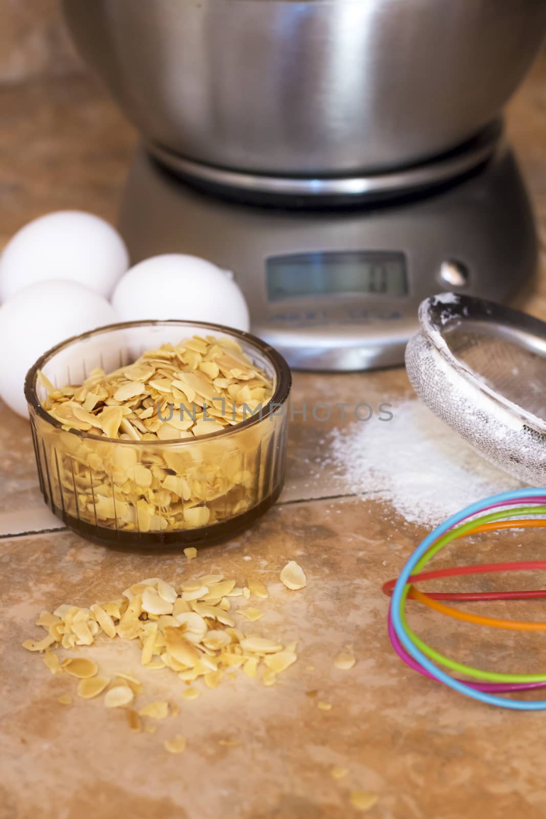 three eggs,sliced almonds and gray metal scale,sieve flour and colorful whip