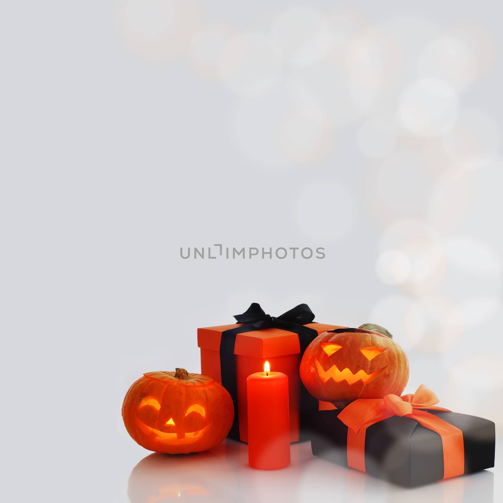 Halloween pumpkin and gifts on gray background