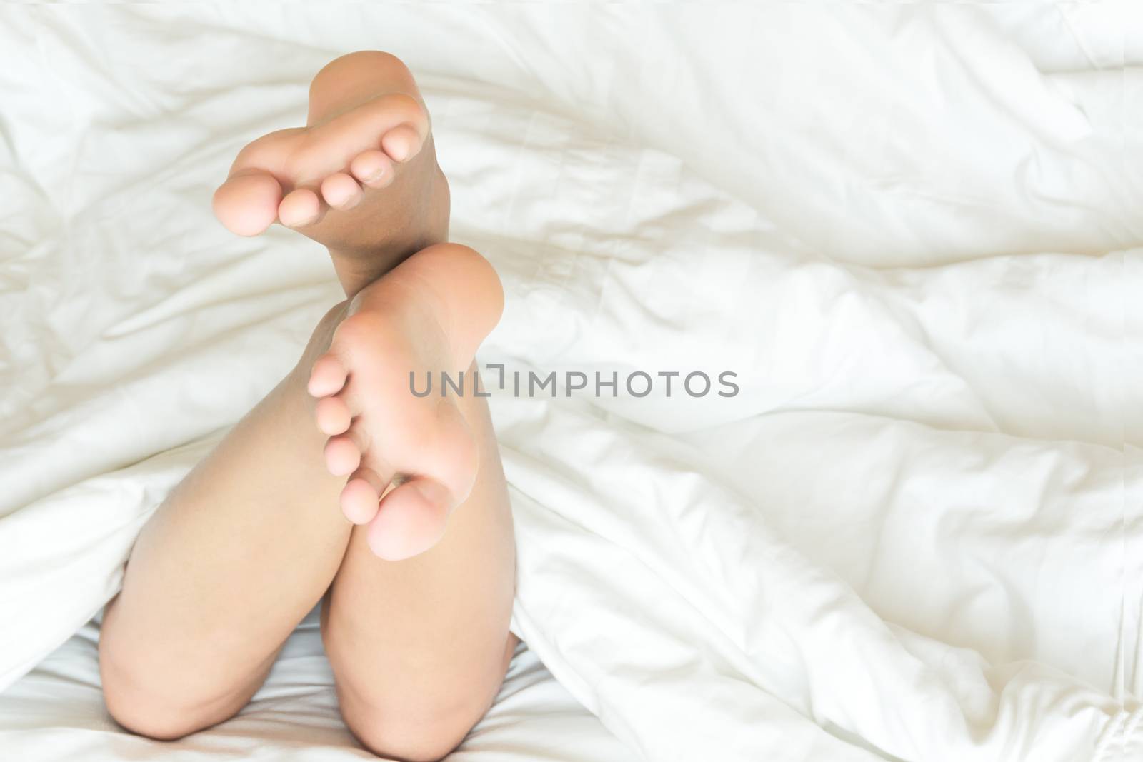 Closeup woman feet relaxing and happy time on white bed, beauty  by pt.pongsak@gmail.com