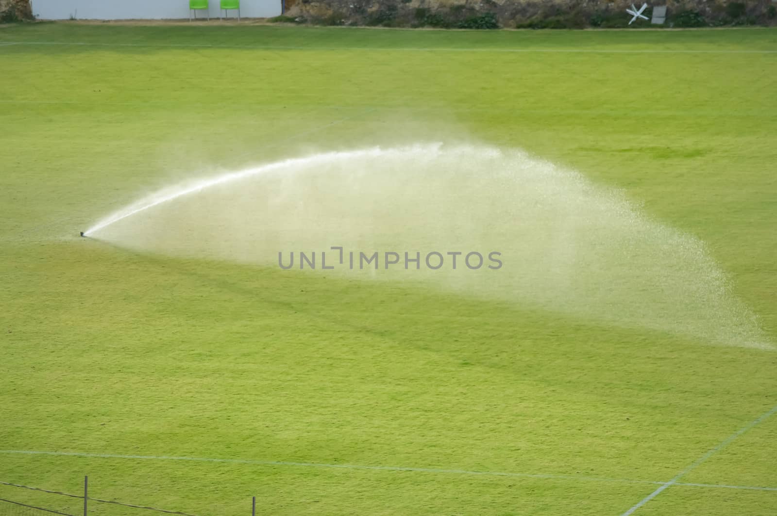 Automatic watering of a lawn in a football field