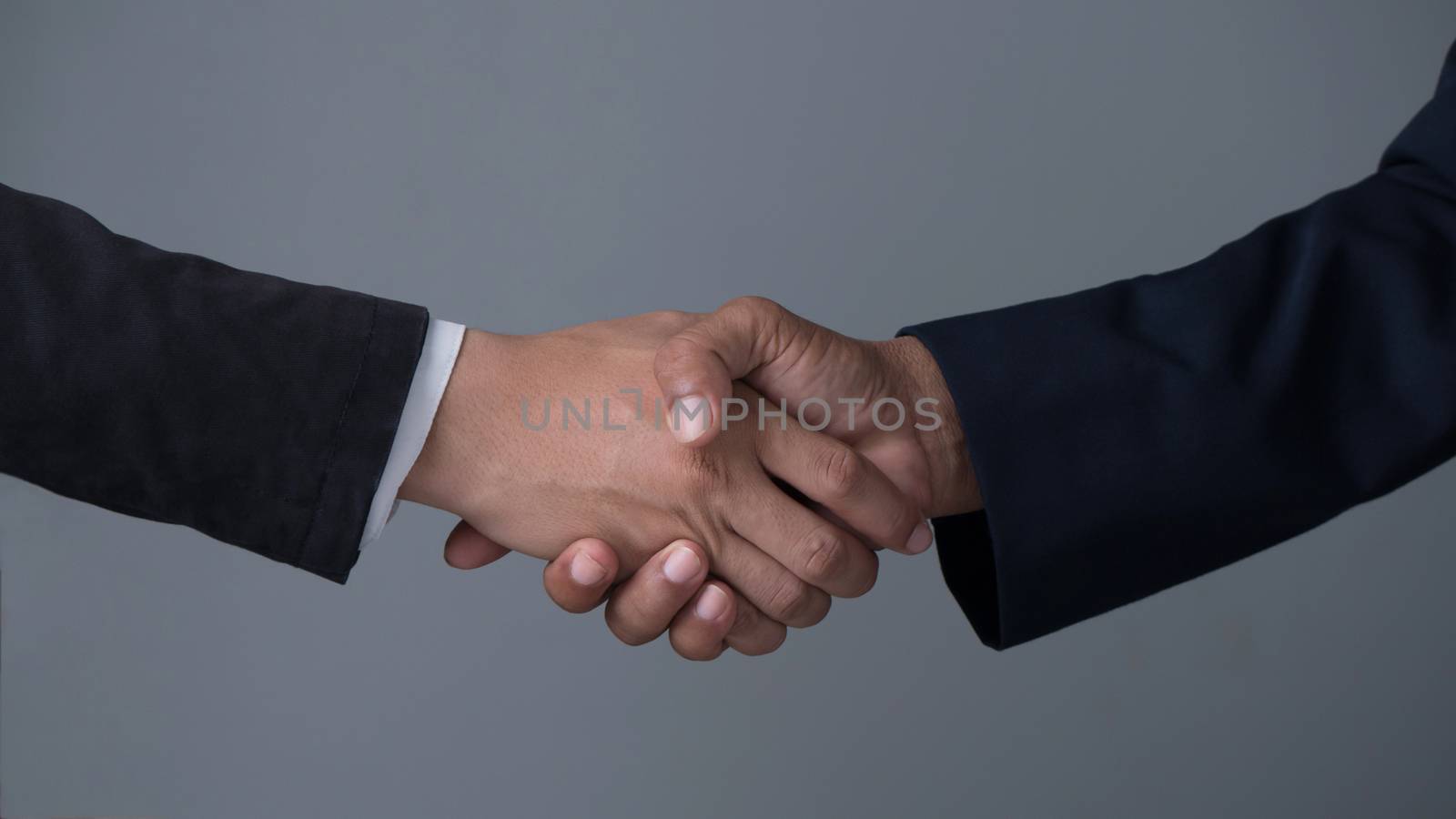 Image businessman handshake , Hand holding on gray background