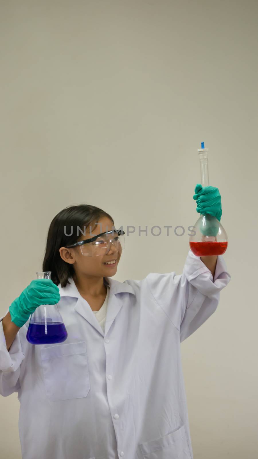 Asian little girl holding test tube or laboratory flask . Education concept.