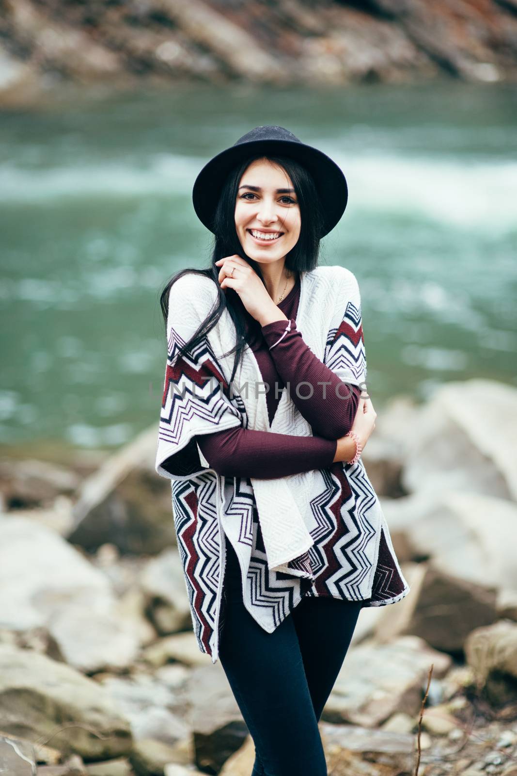 girl in warm sweater walking along a mountain river, love story