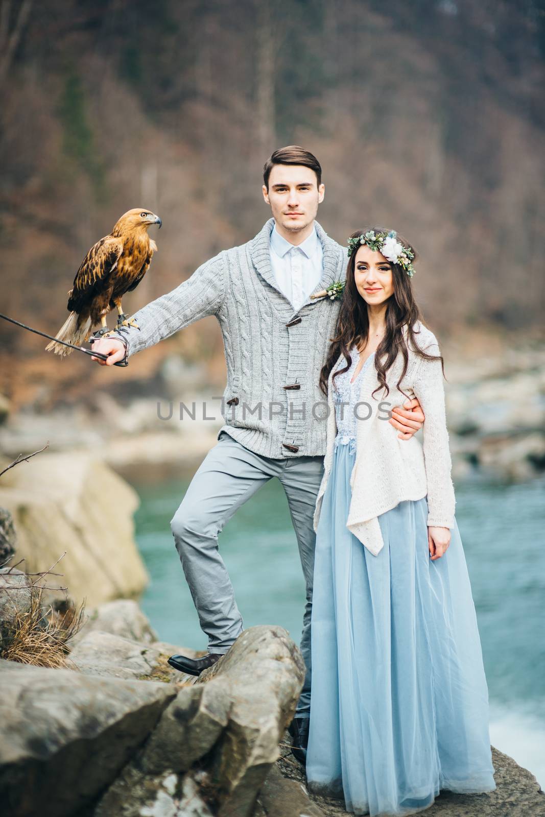 Сouple of newlyweds in the Carpathian waterfall, a wedding walk