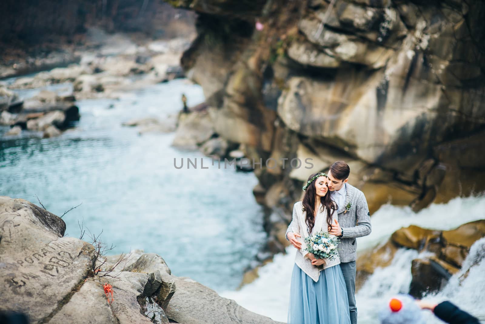 Сouple of newlyweds in the Carpathian waterfall, a wedding walk