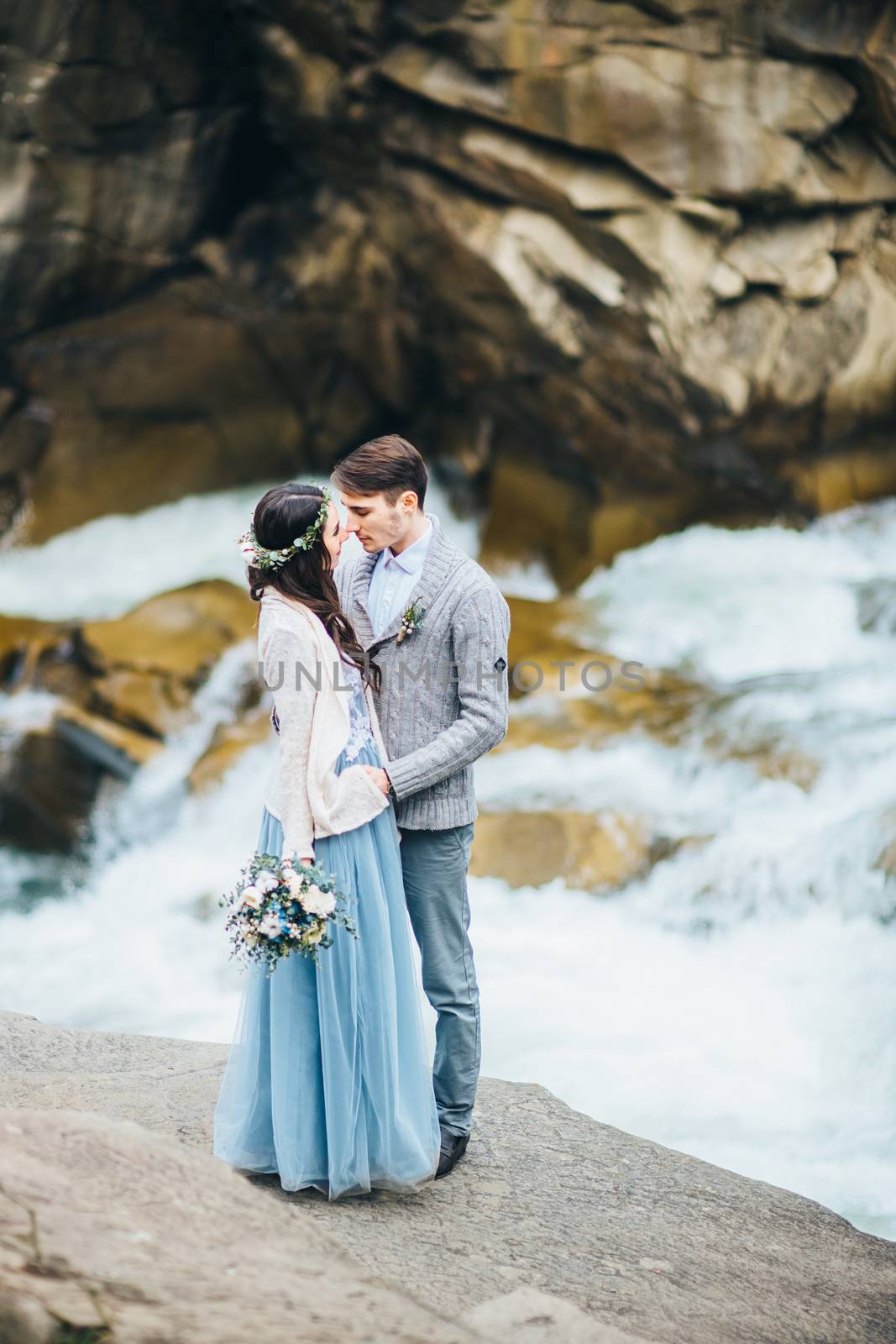 Сouple of newlyweds in the Carpathian waterfall, a wedding walk