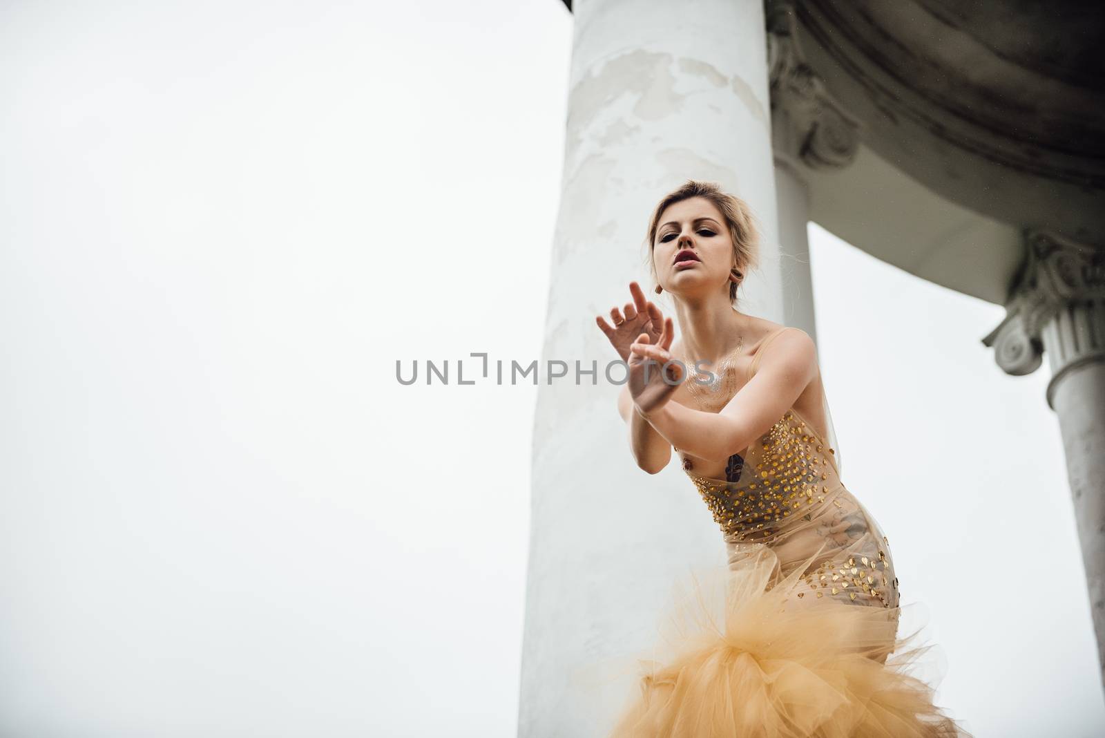 model girl dress gold angel posing in the woods near the old columns