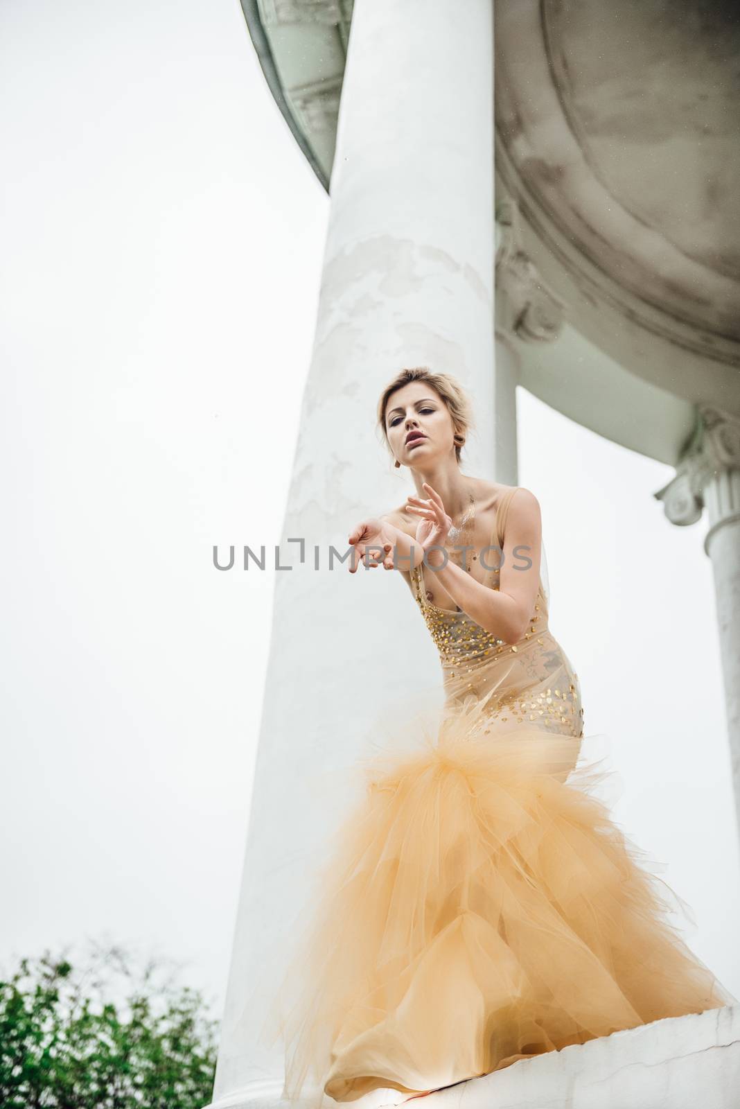 model girl dress gold angel posing in the woods near the old columns