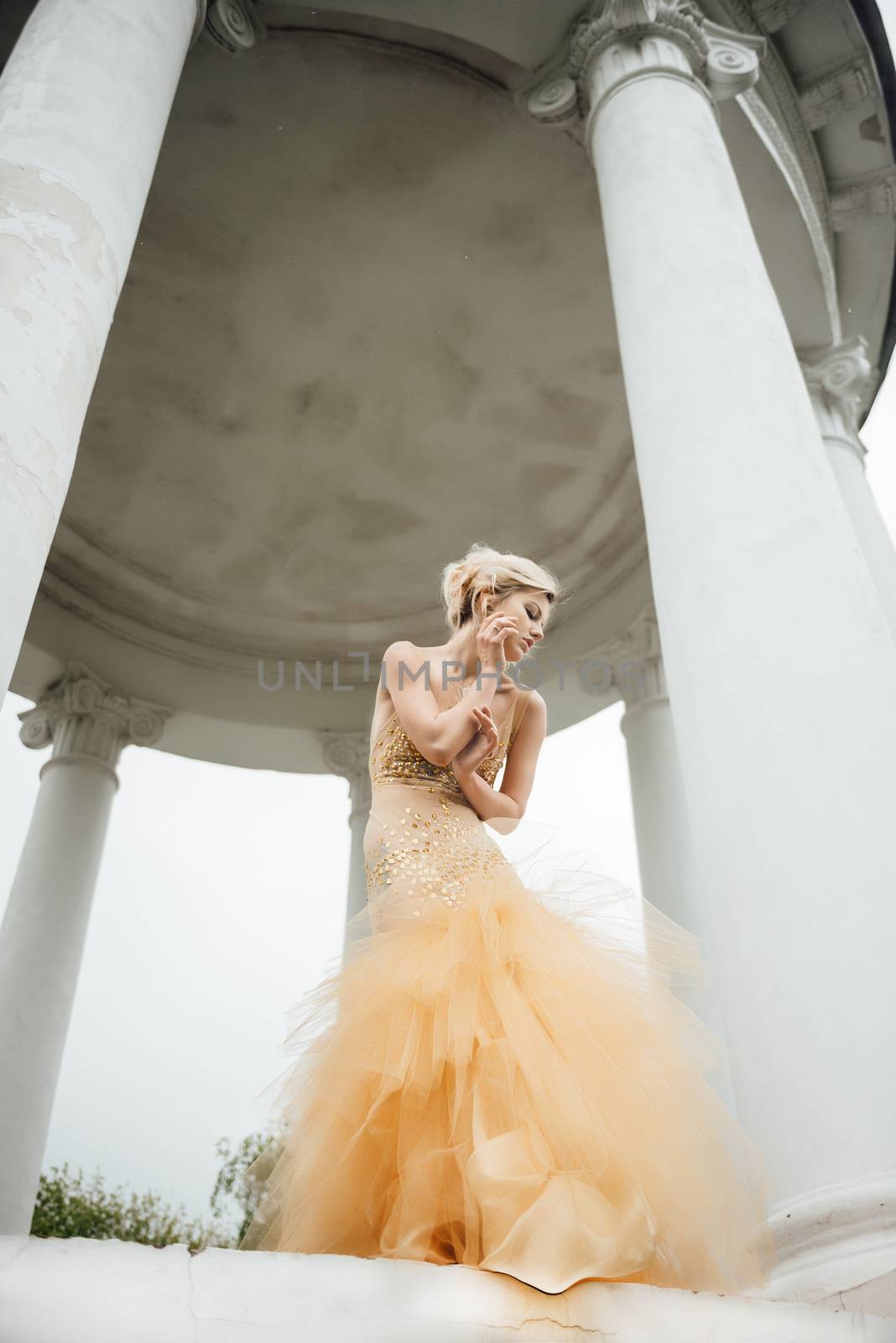 model girl dress gold angel posing in the woods near the old columns