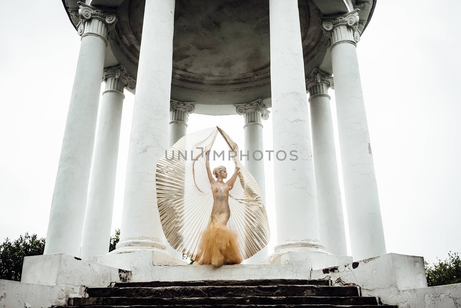 model girl dress gold angel posing in the woods near the old columns