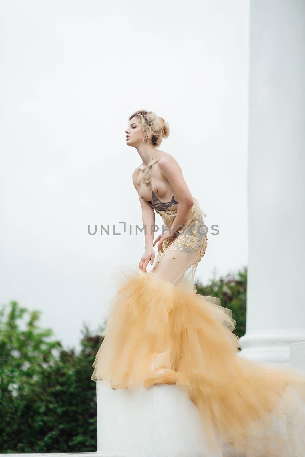 model girl dress gold angel posing in the woods near the old columns