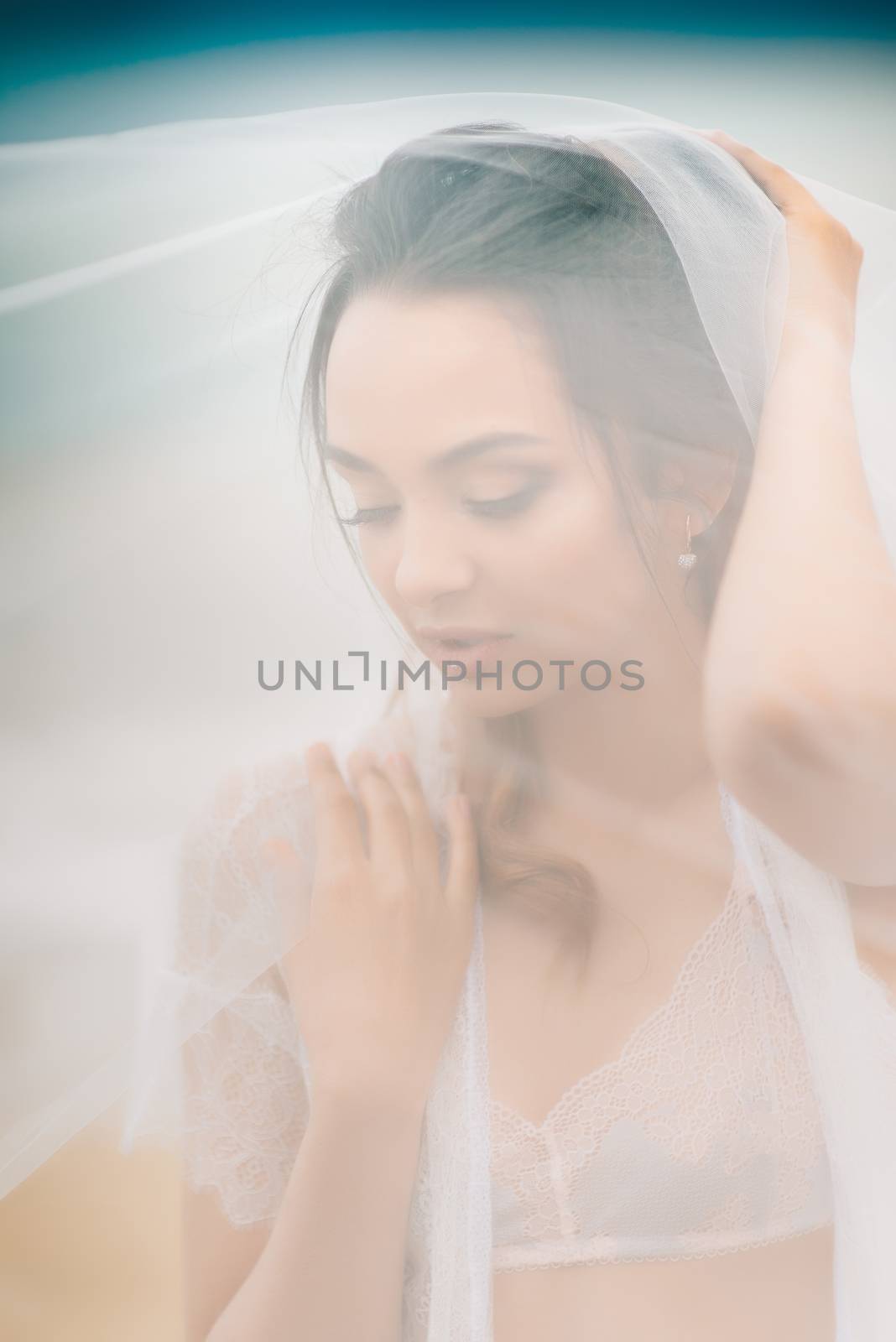 bride close-up under a veil against a background of blue sky and black sea