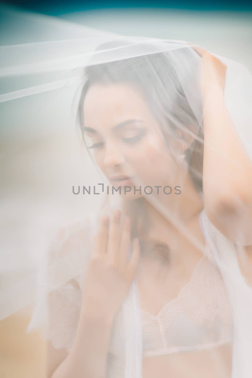 bride close-up under a veil against a background of blue sky and black sea