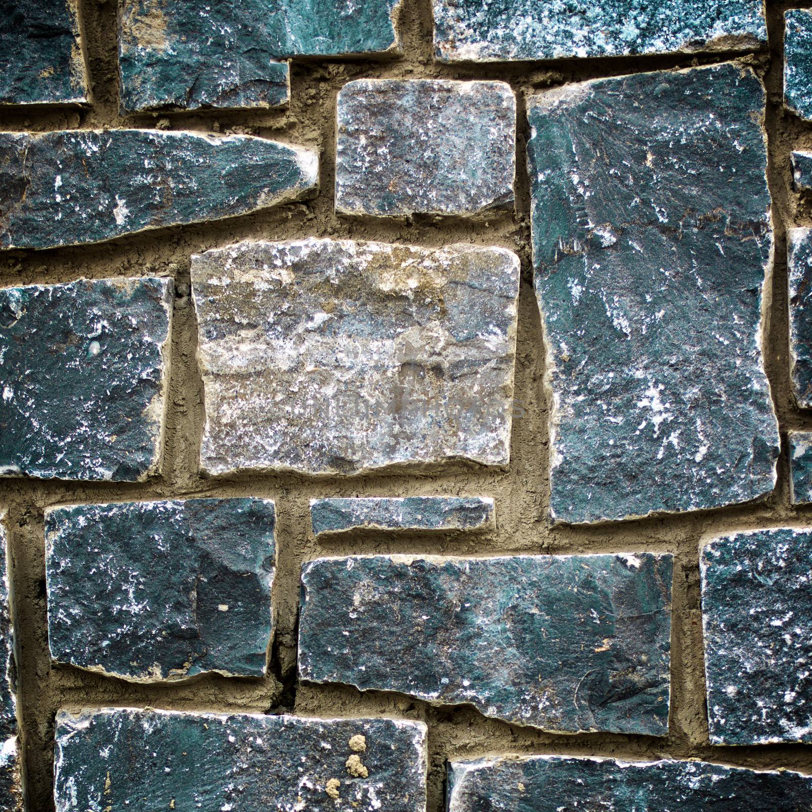 Obsolete Stone Wall Background with Various Shape Weathered Blocks closeup Outdoors