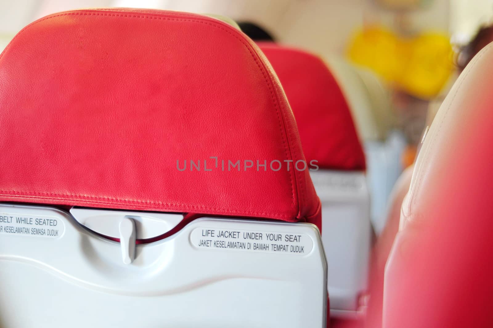 airplane seat with belt while seated and life jacket under your seat text