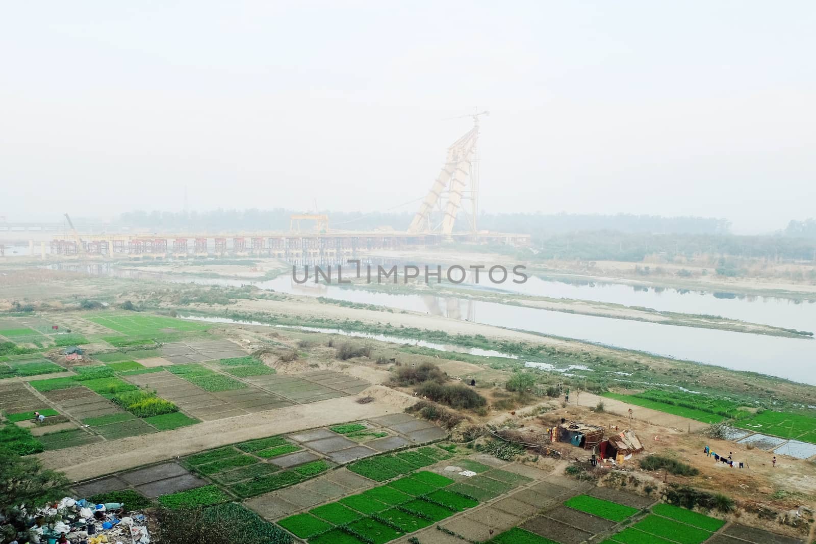 The bridge over the Yamuna River in Delhi with vegetable beds on the shore