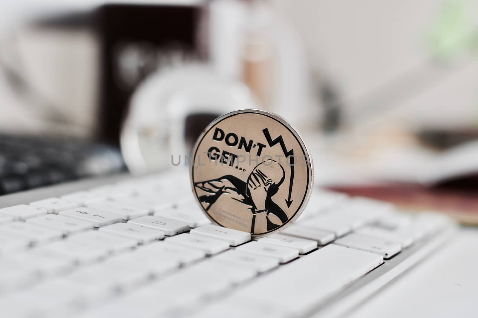 Digital currency physical metal bitcoin coin on the white keyboard near glass ball.