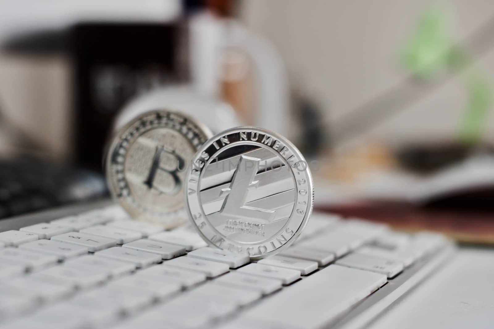 Digital currency physical metal bitcoin coin on the white keyboard near glass ball.