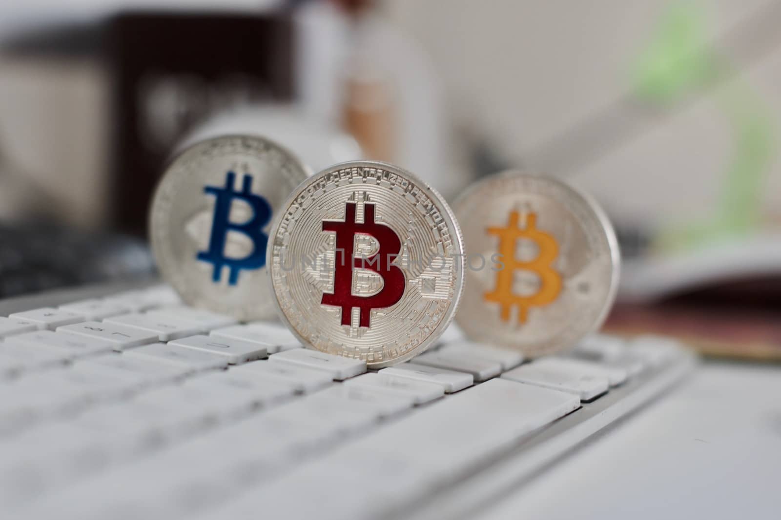 Digital currency physical metal bitcoin coin on the white keyboard near glass ball.