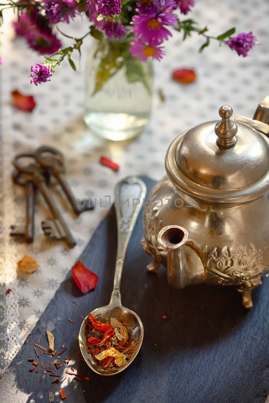 Dry tea leaves on spoon on ardesia plate