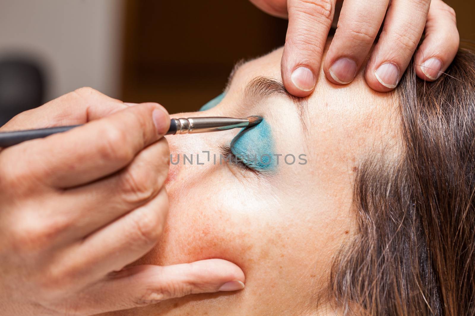 Make up artist applying eyeshadow to a woman