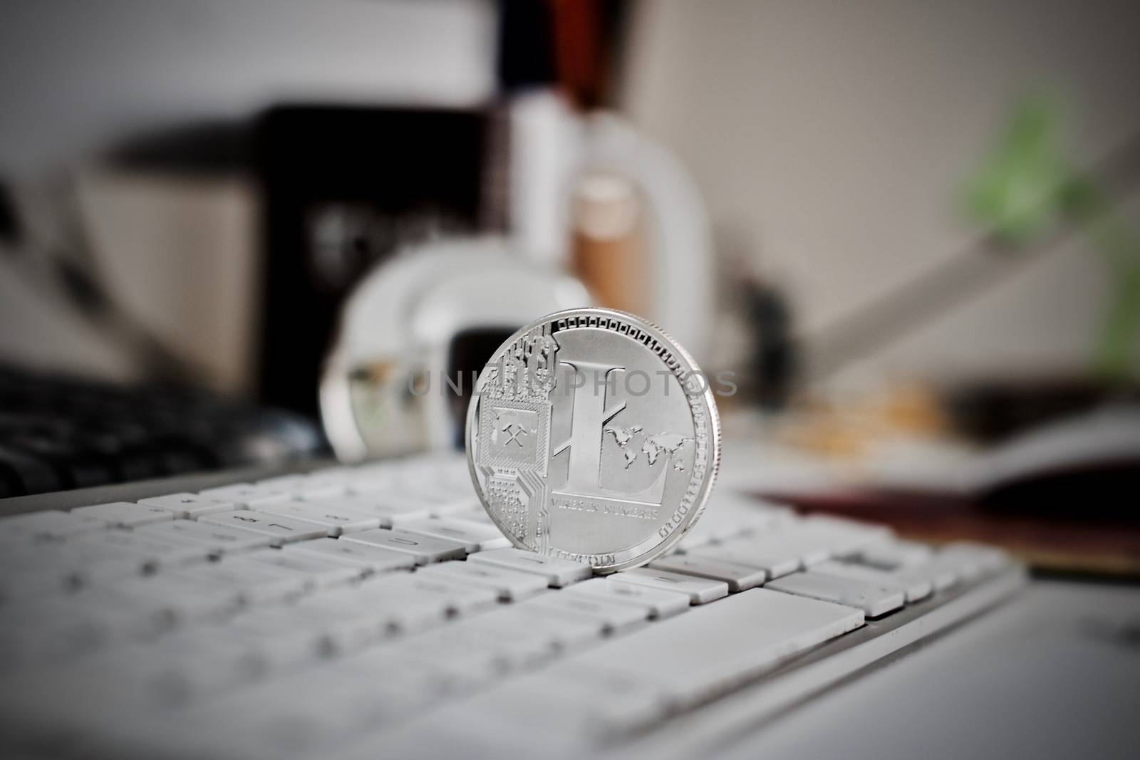 Digital currency physical litecoin coin on the white keyboard. Computer concept.