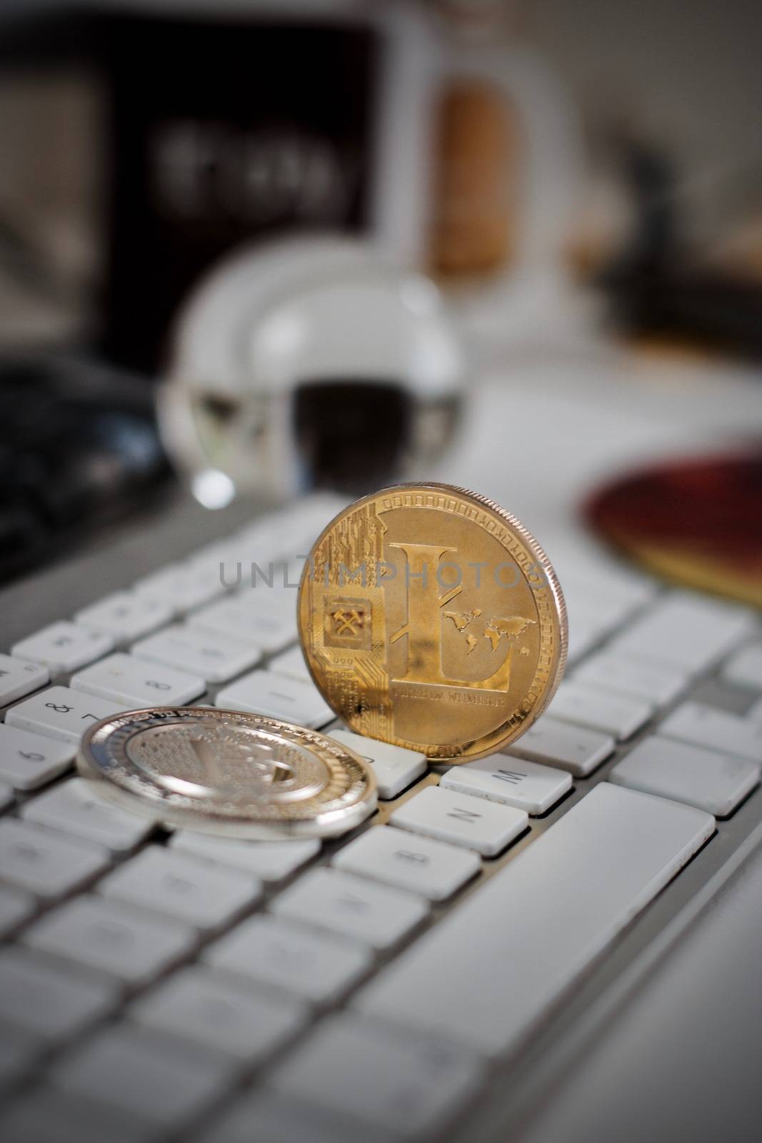 Digital currency physical litecoin coin on the white keyboard. Computer concept.